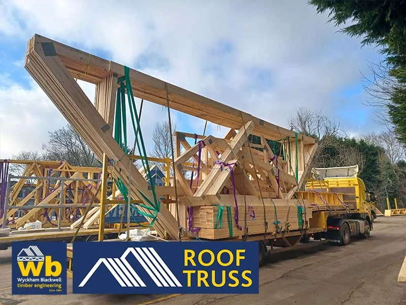 Timber roof trusses and other products on back of lorry with cloudy blue sky in background